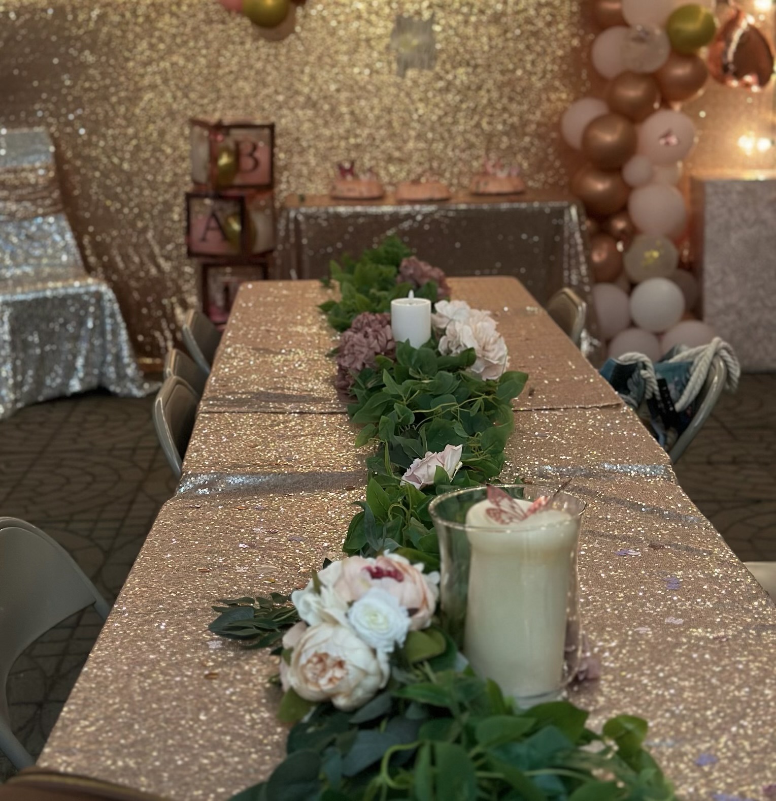 Sparkling gold table runner with greenery and candles