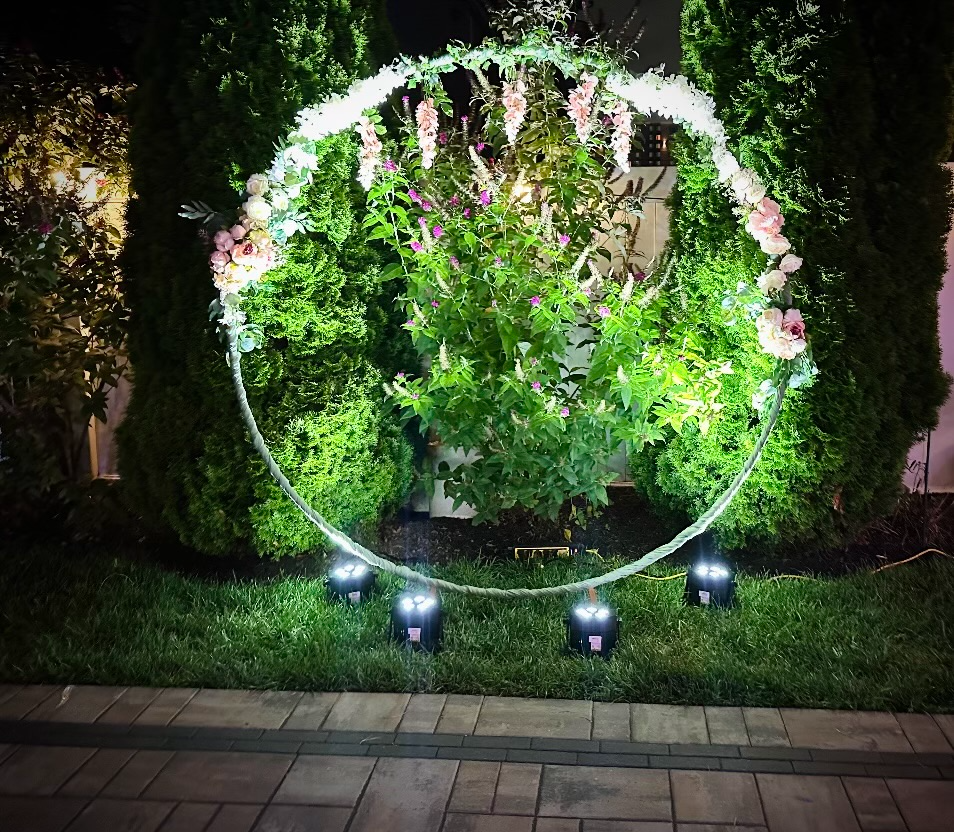 Floral circle backdrop with uplighting in a garden